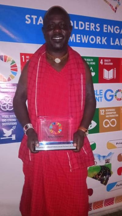 Man recieves award in front of SDG banner